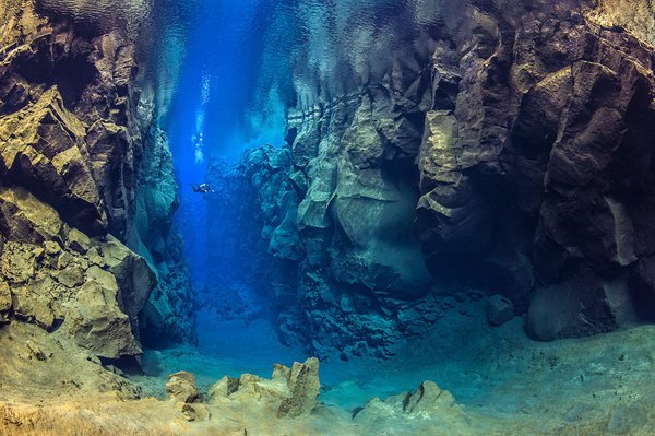 A diver explores the cathedral at Silfra canyon, a deep fault filled with fresh water in the rift valley between the Eurasian and American tectonic plates) at Thingvellir National Park, Iceland. In this photo the American plate is on the left and the Eurasian plate on the right. Model released.