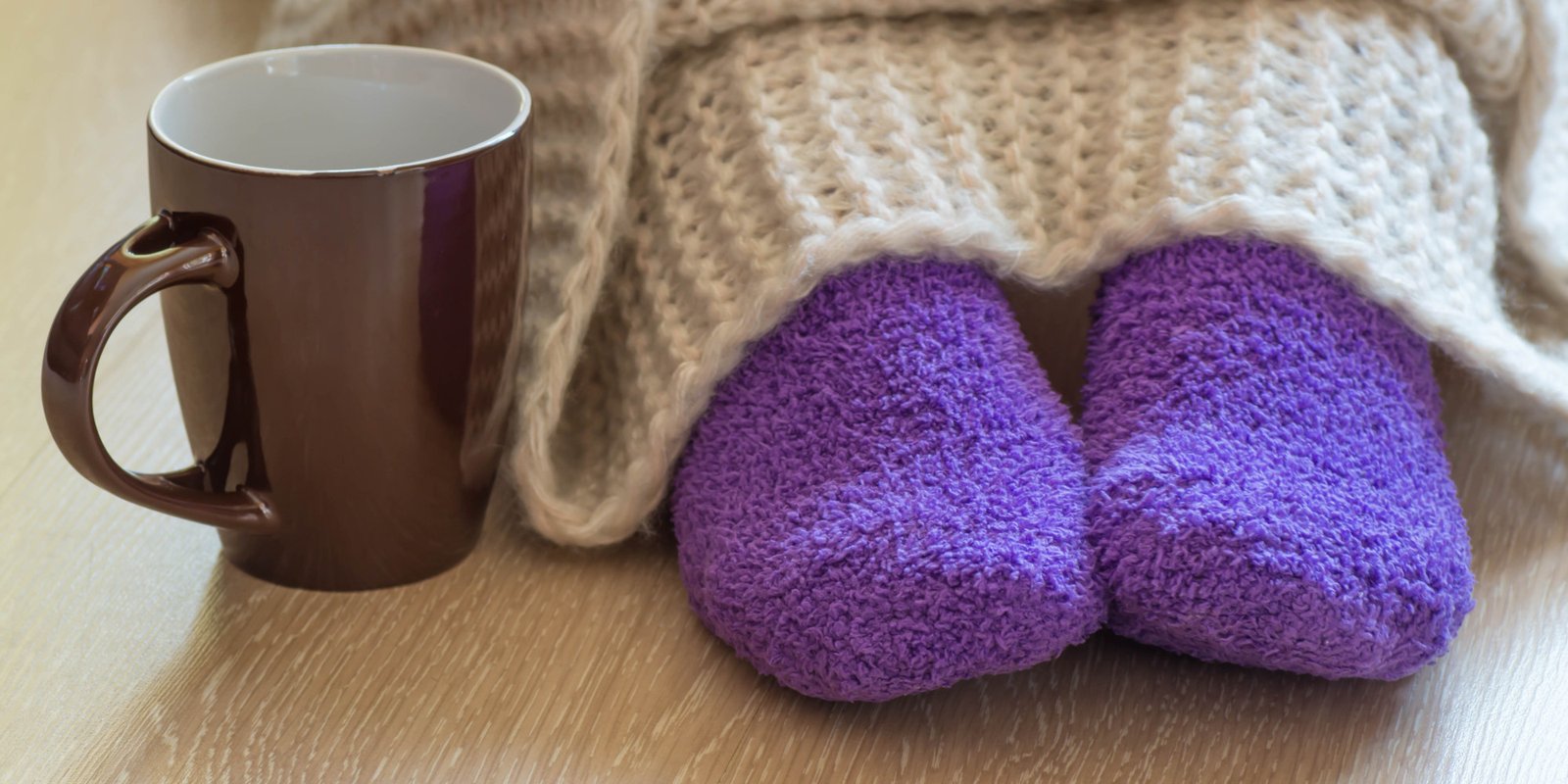 Cold concept with teacup near the legs